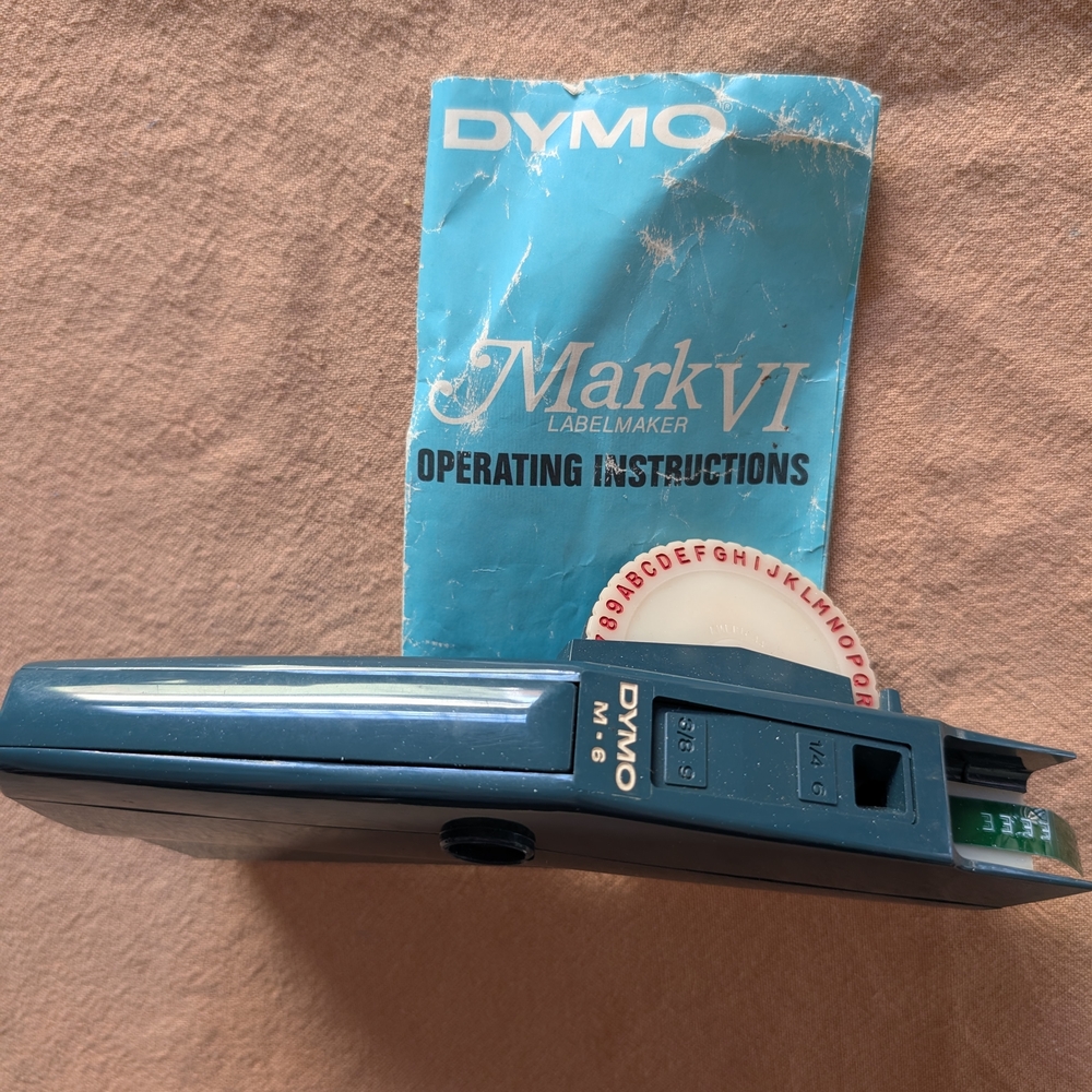 Dymo teal handheld label maker with instruction booklet